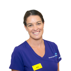 Kelly smiles at the camera in her work uniform.