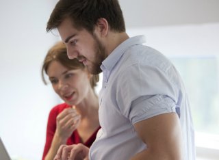 A male and a female student looking at a laptop