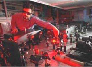 Man with safety glasses tweaking a laser beam in a laboratory