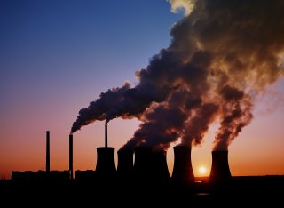 Power station with large amounts of smoke pouring from the top