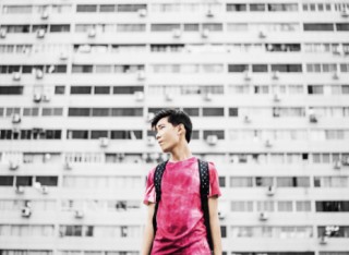 young person standing against wall