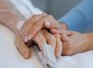 Two hands holding in hospital