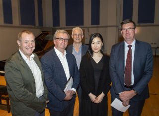 Competition winner Zixuan Yu is joined by the panel of judges