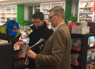 Three men standing in bookshop