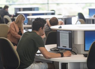 Students studying by computer clusters in Innovation for Health building