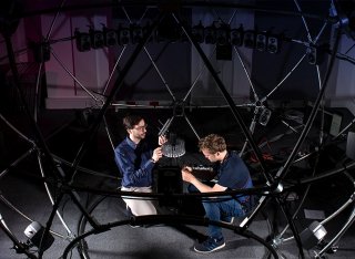 Two men adjusting the sound sphere facility equipment