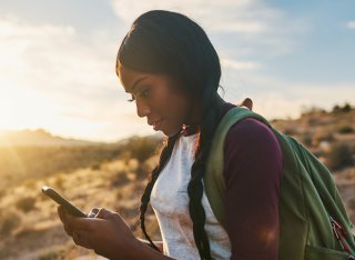 Woman backpacking using phone