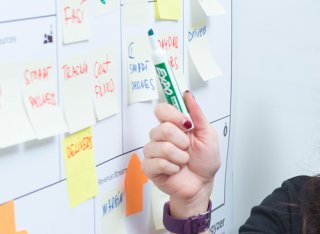 Person pointing to whiteboard with marker pen