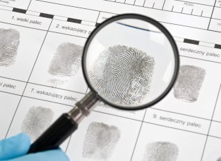 Fingerprints being analysed under a magnifying glass
