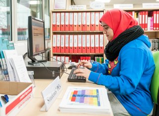 Female student sitting at a PC.