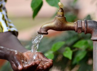 Hand cupping water coming out of a tap.
