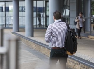 A man walking outside the Rik Medlik building at the University