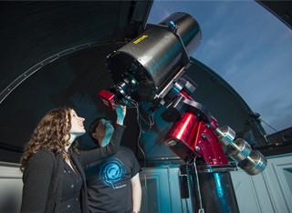 Woman using a large telescope