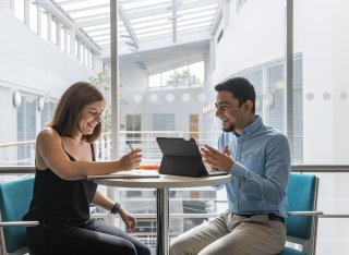 Two students working together and smiling