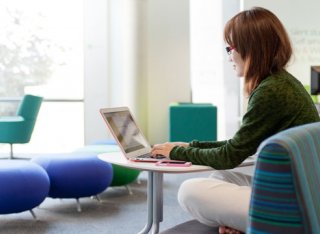 Female student studying in the Library on her laptop