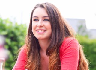 Student sat smiling at a table