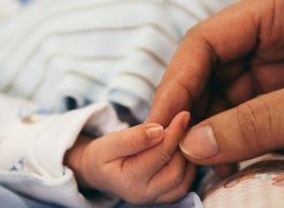 parent holding baby's hands