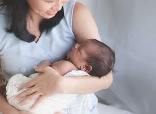 A women cradling a new born baby