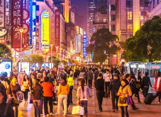 Crowds of people walking through city at night