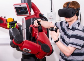 Student wearing virtual reality headset working with a robot
