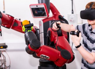 Student wearing virtual reality headset working with a robot