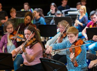 University of Surrey's Orchestra are playing instruments in PATS Studio