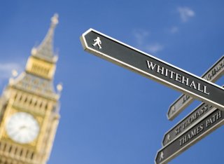 A tourist sign pointing towards Whitehall with Big Ben in the background
