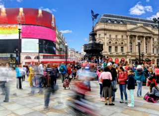 Lots of tourists walk around Piccadilly Circus in London