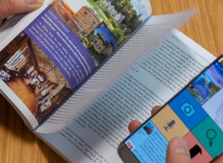 Somebody uses a mobile phone to interact with an augmented travel guide