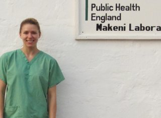 Emma Wise wearing scrubs outside the Makeni Laboratory