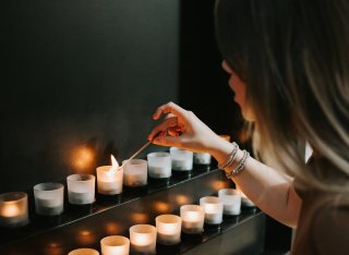 Woman lighting candle for Holocaust Memorial Day