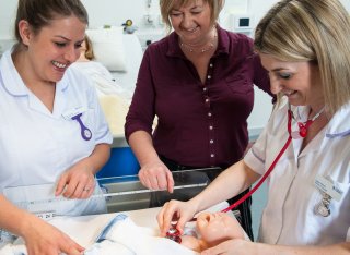 Student midwife the checking breathing of a child mannequin