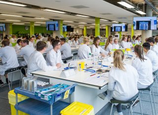 Students sitting in a lab looking at a TV screen