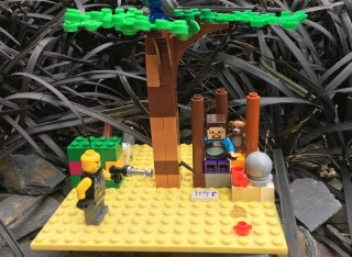 Lego build of man sat under a tree