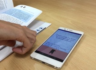 Mobile on a desk with book next to it