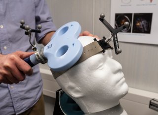 A transcranial magnetic stimulation (TMS) coil being demonstrated on a Styrofoam head. 