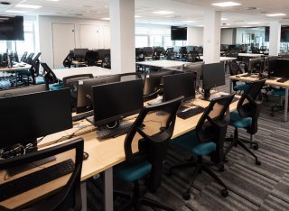 A lecture room full of computers and large television screens