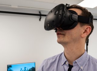 A man using a virtual reality headset in the Psychology extended reality suite.