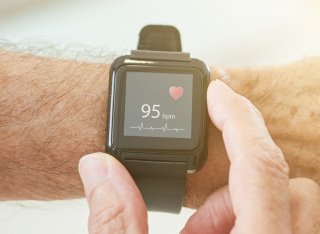 Person wearing a fitness wristband monitoring their heartbeat