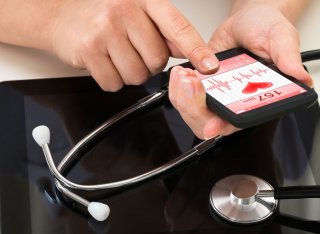 Person holding mobile with heart data on screen