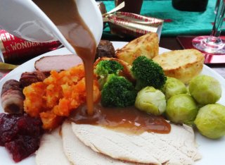 Gravy being poured over a roast dinner