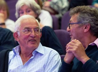 Two men chatting in the audience of the Roland Clift lecture
