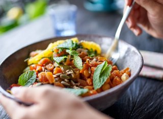 Person eating salad from a bowl