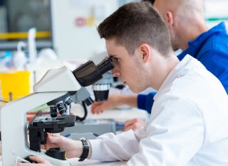 Student looking down a microscope