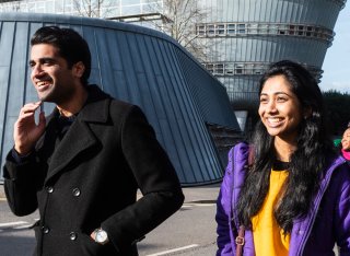 Three students walking by the Duke of Kent Building