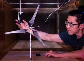 Student placing equipment into wind tunnel to test