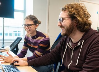 Two students sitting in front of a computer