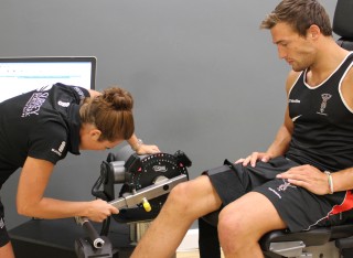 A woman carrying out a fitness assessment on a sports person