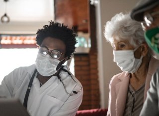 Doctor and patients sat together masked up