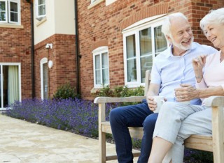 Elderly couple sitting on a bench outside